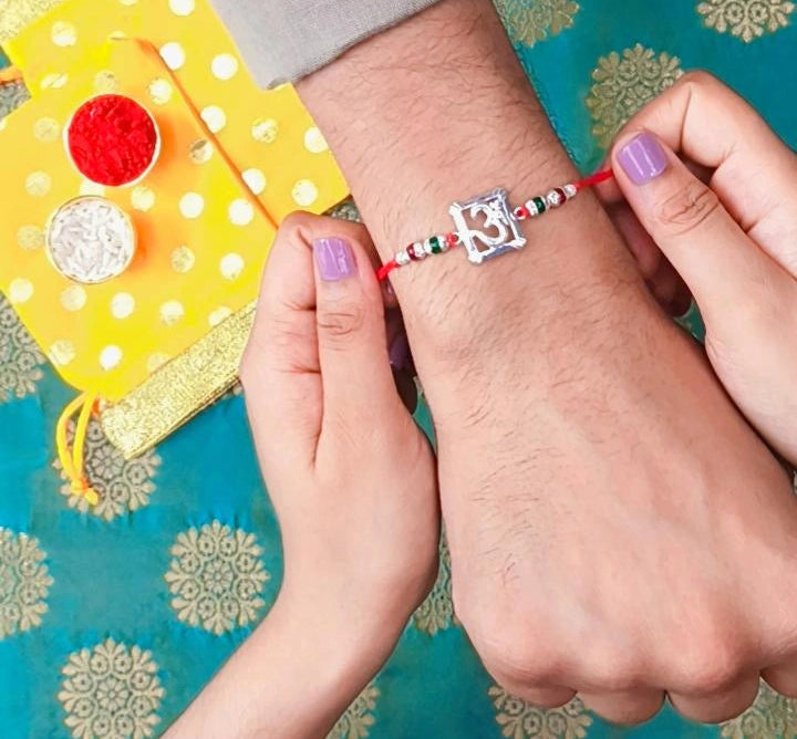 Silver Om Symbol Rakhi with Red Thread